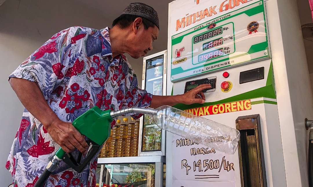 Edy saat mengoperasikan pom minyak goreng. (Foto: Aini Arifin/Ngopibareng.id)