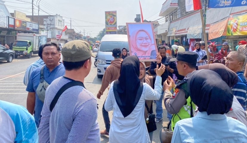 Ibu Korban Tragedi Kanjuruhan, Juariyah saat mengangkat foto anaknya yang meninggal ketika kunjungan Presiden Jokowi (Foto: Lalu Theo/Ngopibareng.id)