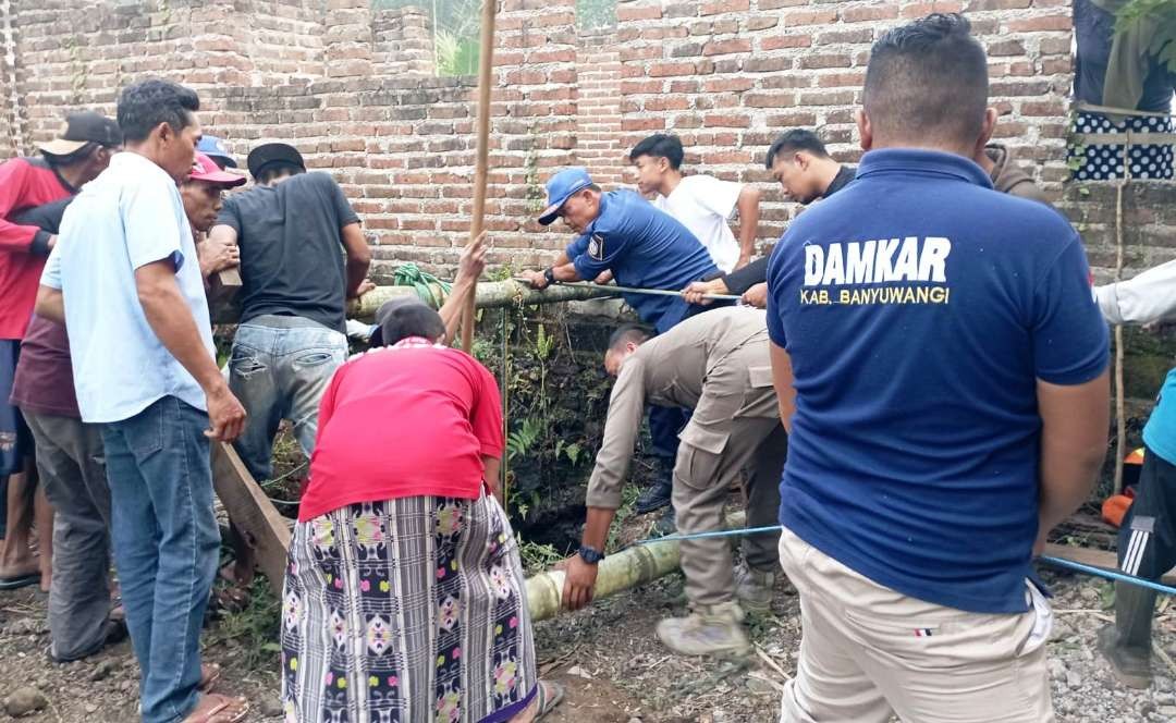 Petugas bersama warga bahu-membahu mengevakuasi sapi yang terjatuh ke sumur. (foto: istimewa)