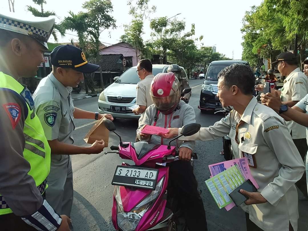 Polisi dan pegawai di sejumlah instansi pemerintah di Bojonegoro berada di beberapa titik, seperti di traffic light Jalan Ahmad Yani Kecamatan Kota Bojonegoro, pada Rabu 26 Juli 2023.(Foto: dok. Polres Bojonegoro)