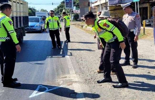 Anggota Satlantas Polres Situbondo melakukan olah TKP pesepda meninggal terlindas truk kontainer.(Foto:Guido/Ngopibareng.id)