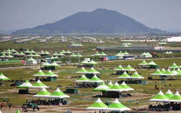 Peserta Jambore Pramuka Dunia di Korea Selatan berteduh di gazebo sambil menunggu evakuasi. (Foto: Reutrs)