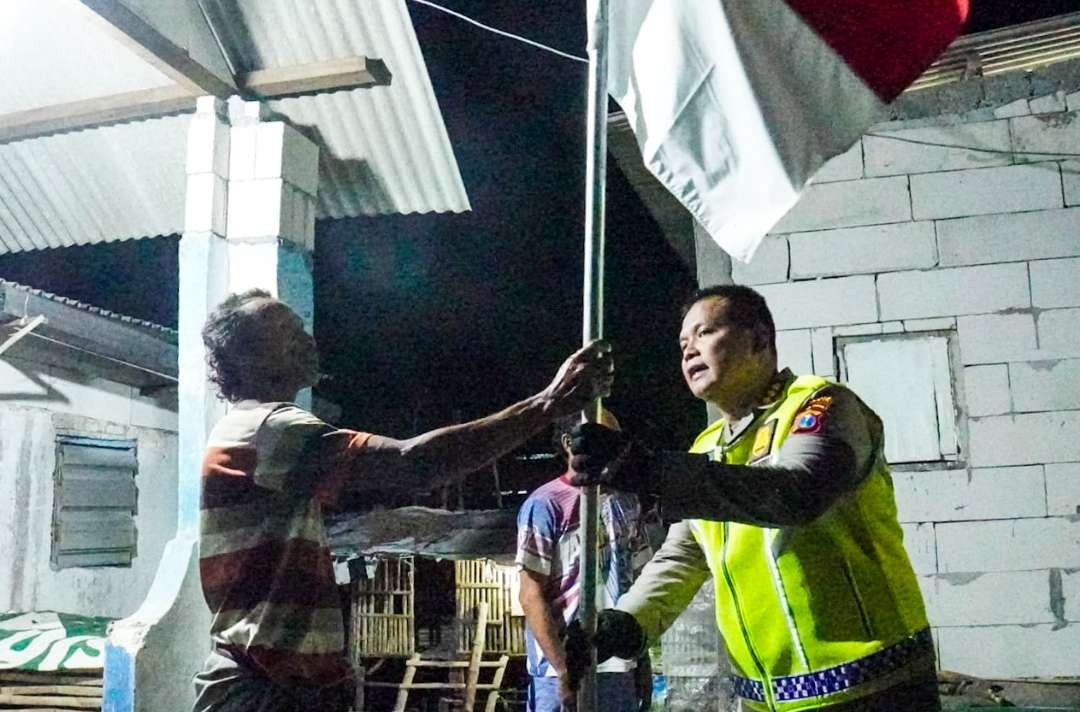 Kapolresta Sidoarjo membagikan bendera ke nelayan di Sidoarjo, Jawa Timur. (Foto: Aini Arifin/Ngopibareng.id)