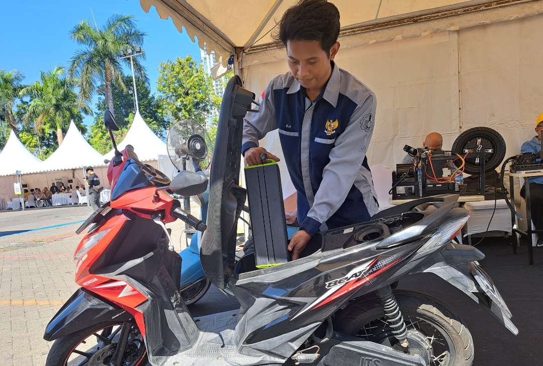 Mahasiswa ITS yang tergabung dalam STP saat menunjukan motor matic yang sudah dikonversi ke motor listrik dalam acara sosialisasi ESDM di Grand City Mal, Surabaya. (Foto: Pita Sari/Ngopibareng.id)