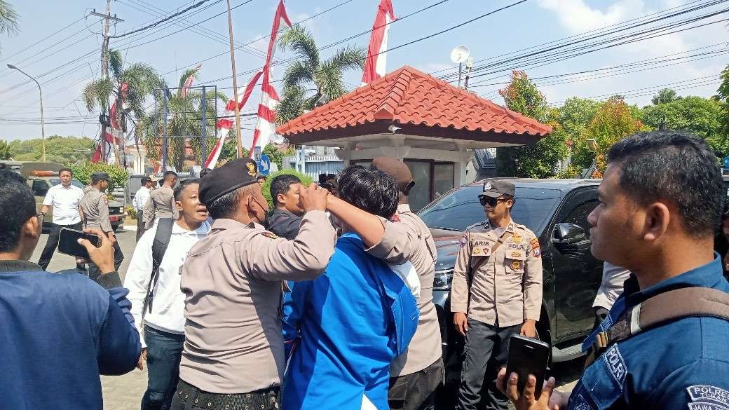 Salah satu mahasiswa saat hendak diamankan oleh aparat kepolisian. (Foto: Khoirul Huda/Ngopibareng.id)