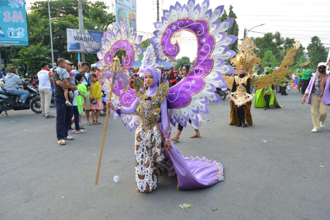 Peserta karnaval dengan kostum karnival berjalan di bawah terik matahari. (Foto: Ist)