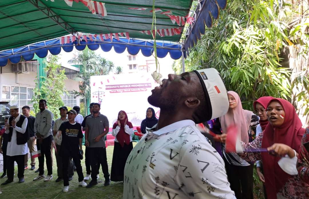 Mahasiswa asing yang mengikuti lomba makan kerupuk di halaman Kampus Unusa B. (Foto: Pita Sari/Ngopibareng.id)