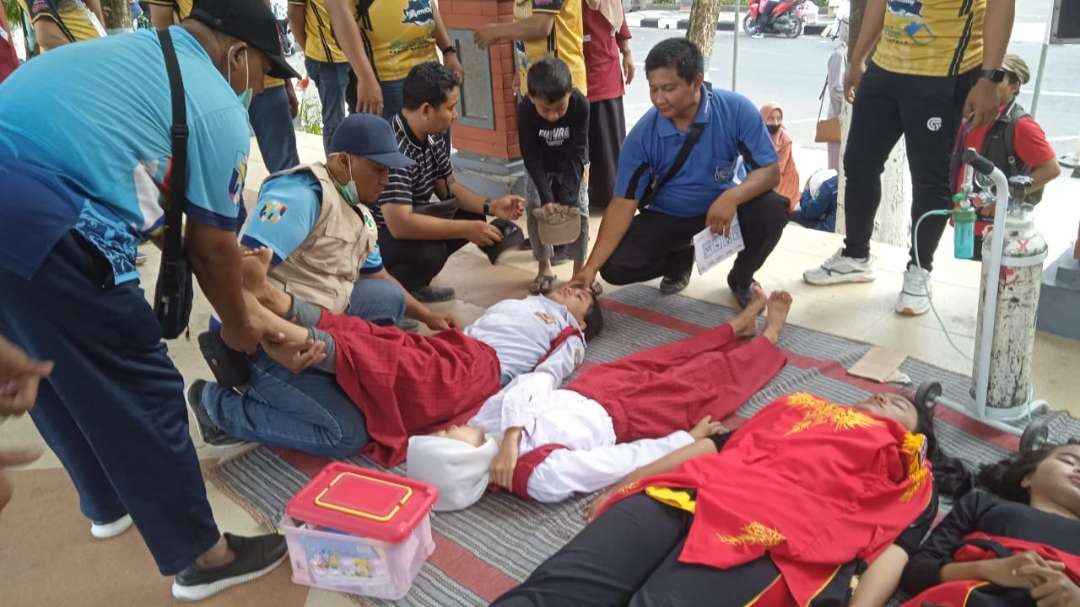 Peserta gerak jalan di Lamongan saat dalam perawatan medis karena pingsan. (Foto: Imron Rosidi/Ngopibareng.id)