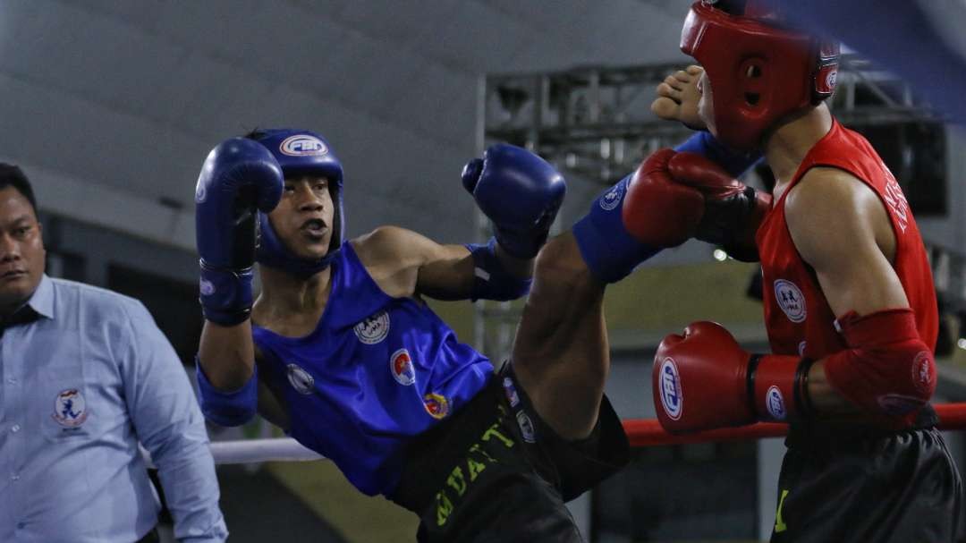 Atlet Muaythai Jatim, Tommy Bagus (biru) saat melawan Yogi Permana (merah) dari NTB di babak semifinal BK PON kelas 54 Kg putra di Gelora Pancasila, Surabaya, Jumat 25 Agustus 2023 malam. (Foto: Fariz Yarbo/Ngopibareng.id)