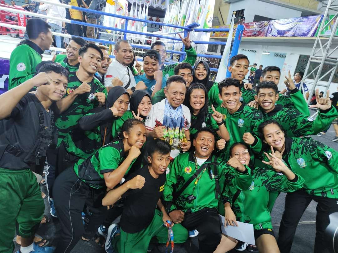 Ketua Pengprov Muaythai Jatim, Baso Juherman (kaos putih-tengah) merayakan gelar juara umum BK PON XXI Aceh-Sumut 2024. (Foto: Fariz Yarbo/Ngopibareng.id)