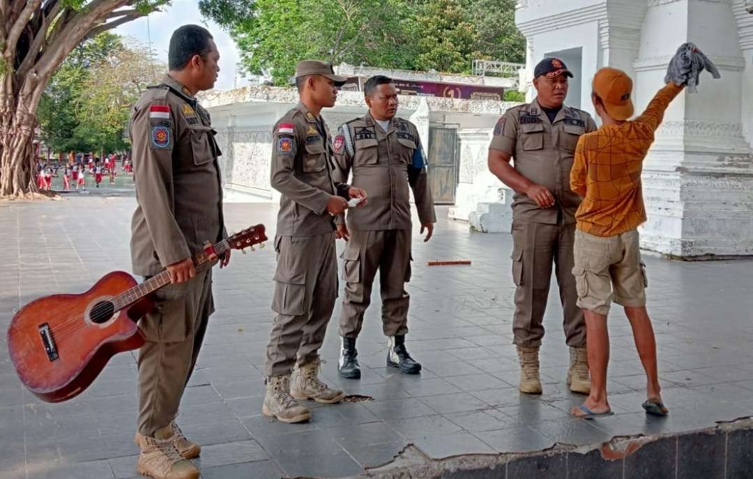 Petugas Satpol PP membujuk pemuda untuk dilakukan perawatan. (Foto: Istimewa)