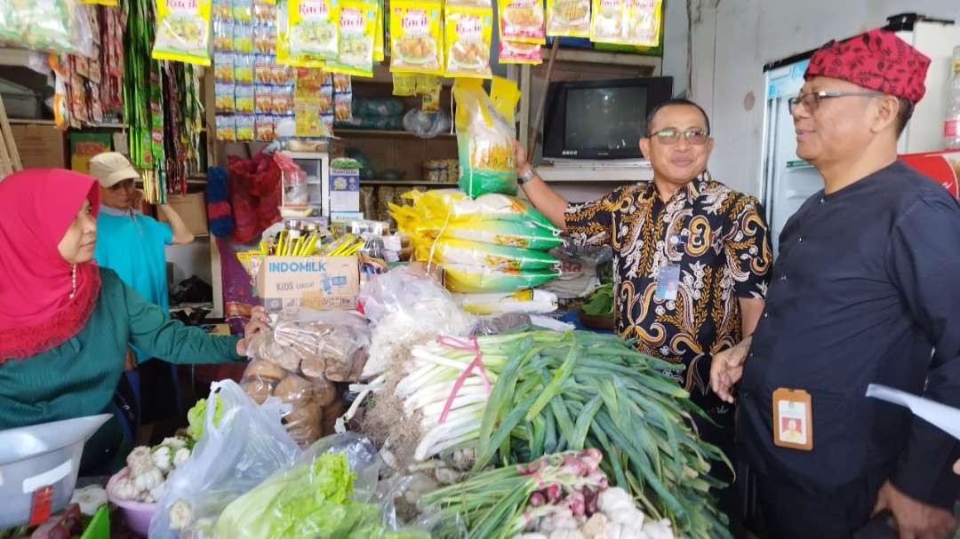 Pimpinan Cabang Bulog Banyuwangi, Harisun (dua dari kiri) bersama Asisten Perekonomian dan Pembangunan Banyuwangi Dwi Yanto mengecek suplai beras SPHP dari Bulog Pasar Banyuwangi (foto: Muh Hujaini/Ngopibareng.id)