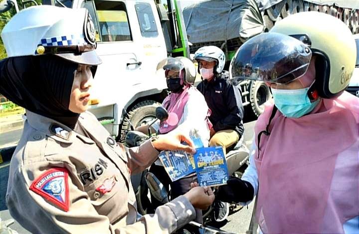 Polwan Satlantas Polres Situbondo diterjunkan membagikan brosur dan stiker Operasi Zebra Semeru 2023 kepada pengendara kendaraan bermotor. (Foto:Guido/Ngopibareng.id)