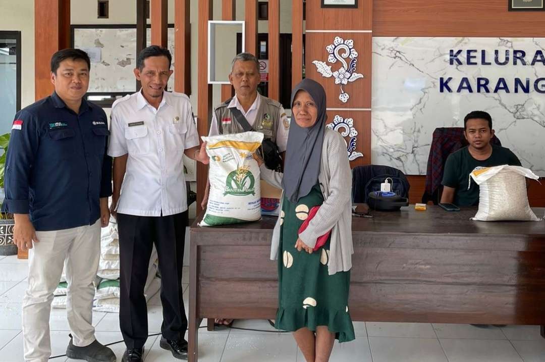 Salah seorang warga menerima bantuan pangan berupa beras (foto: istimewa)