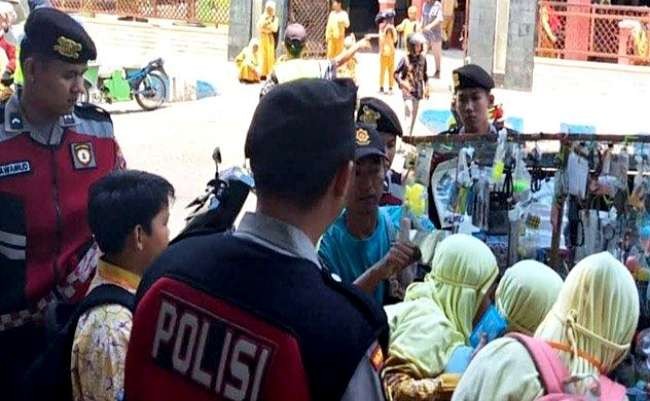 Anggota Satsamapta Polres Situbondo merazia penjual mainan di sekitar SD, guna mencegah penjualan benda tajam berbahaya.(Foto: Guido/Ngopibareng.ud)