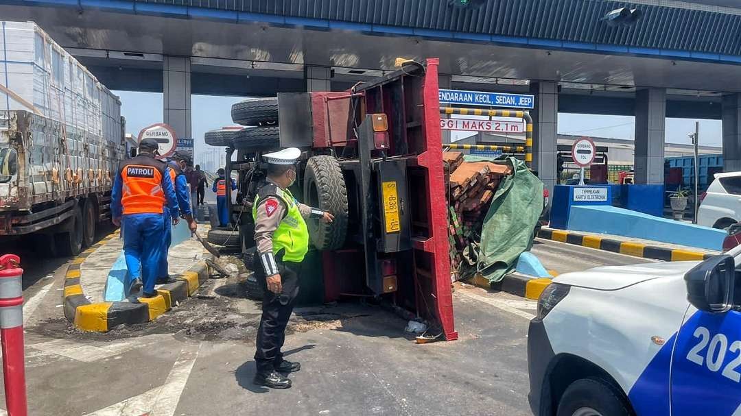 Truk kayu terguling di gerbang tol Tandes Barat, Surabaya, Jumat 13 Oktober 2023. (Foto: Istimewa)