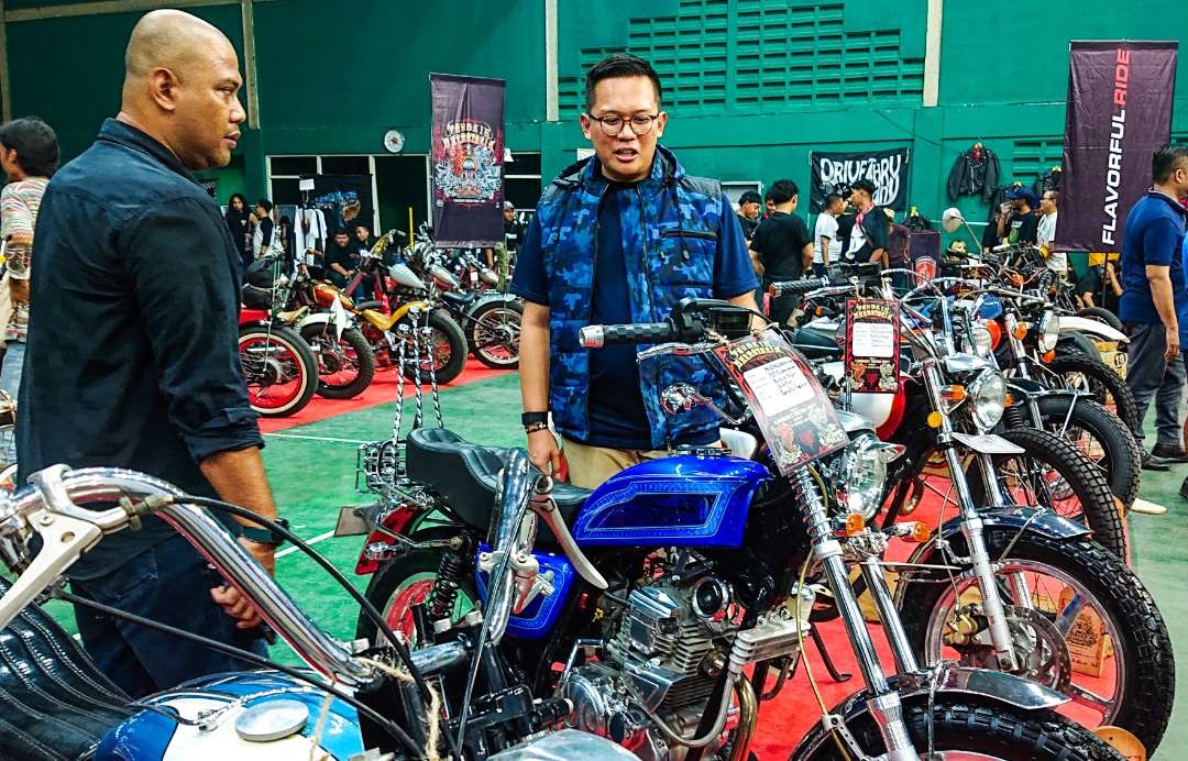 Ali Afandi Mattalitti (rompi biru) saat mengamati salah satu motor custom (foto : Aini/Ngopibareng.id)