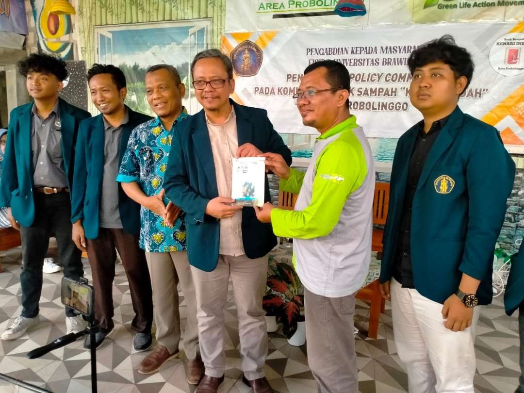 Direktur Bank Sampah “Kenari Indah” Syaifudin Zuhri (nomor dua dari kanan) memberikan kenang-kenangan buku kepada  Ketua Program Studi Doktor Ilmu Sosiologi UB, Dr Wawan Edi Kuswandoro. (Foto: Ikhsan Mahmudi/Ngopibareng.id)