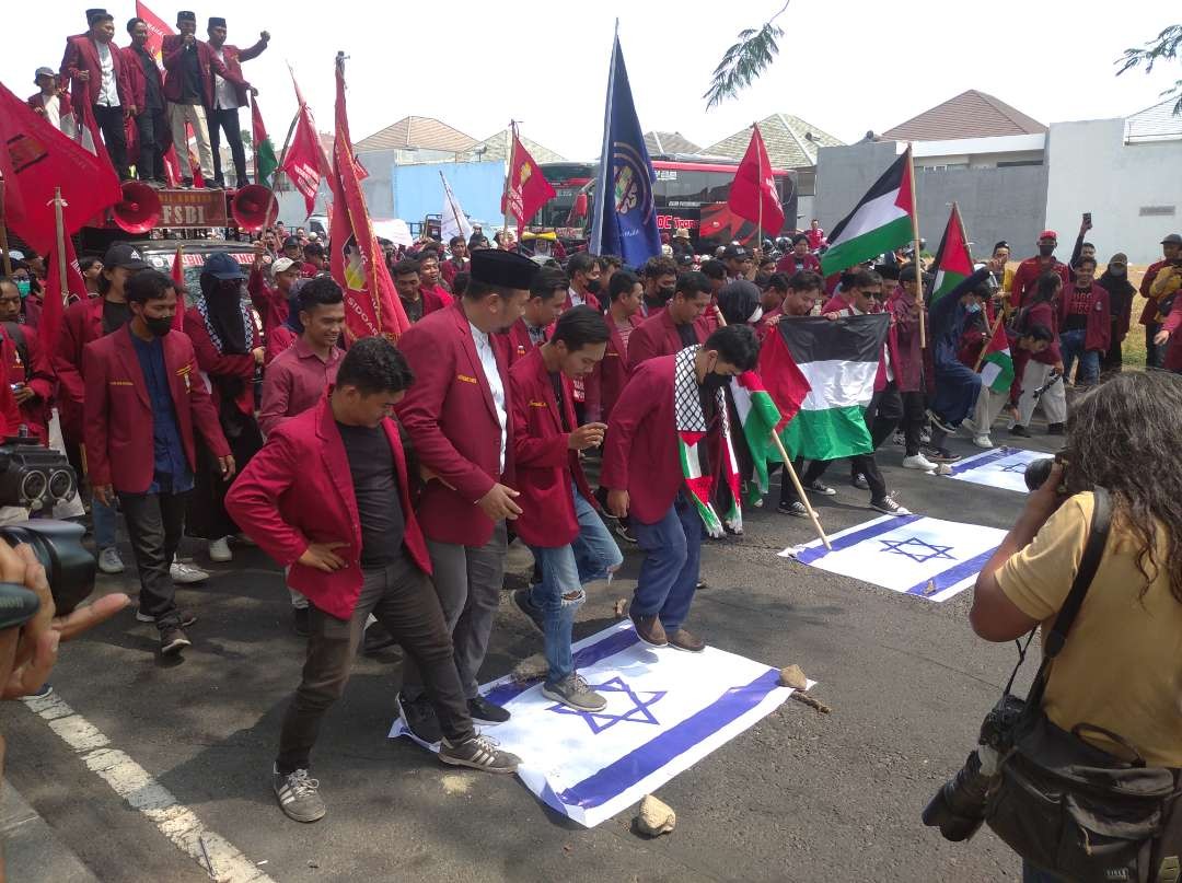 Massa aksi Ikatan Mahasiswa Muhammadiyah Jawa Timur menginjak-injak bendera Israel pada aksi unjuk rasa, Selasa, 7 November 2023 di Konsulat Jenderal Amerika Serikat, Sambikerep, Surabaya. (Foto: Julianus Palermo/Ngopibareng.id)