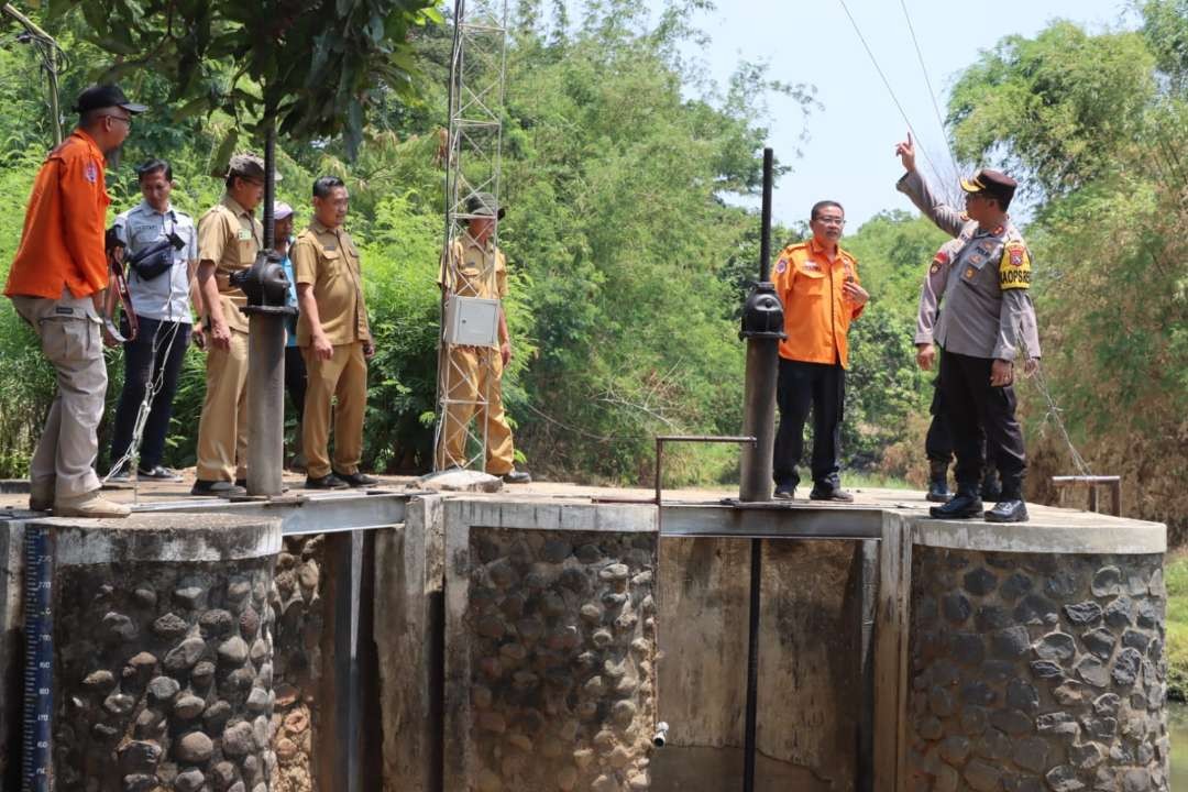 Kapolres Probolinggo Kota, AKBP Wadi Sa'bani (kanan) dan Kalaksa BPBD Kota Probolinggo, Sugito Prasetyo mengecek perangkat EWS di sebuah dam. (Foto: Ikhsan Mahnudi).