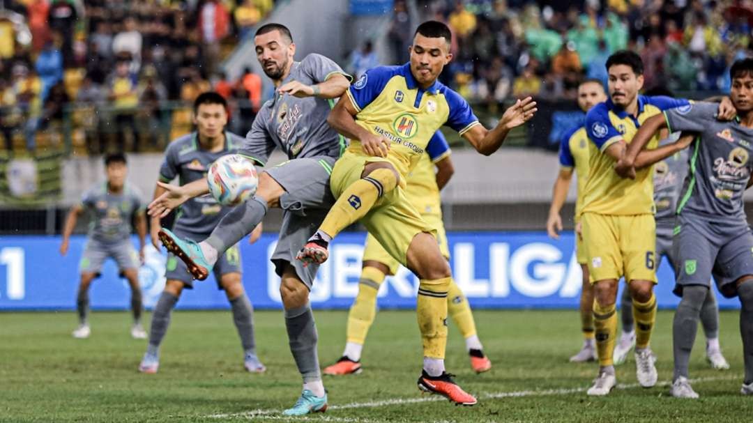 Pemain Persebaya Dusan Stevanovic berduel dengan Pemain Barito Gustavo Tocantins. (Foto: Persebaya)