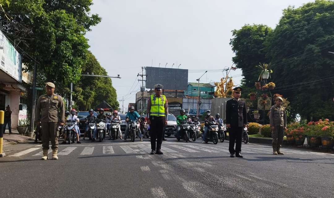 Satlantas Polresta Banyuwangi bersama pengguna jalan mengheningkan cipta untuk mendoakan para pahlawan. (Foto: Muh Hujaini/Ngopibareng.id)