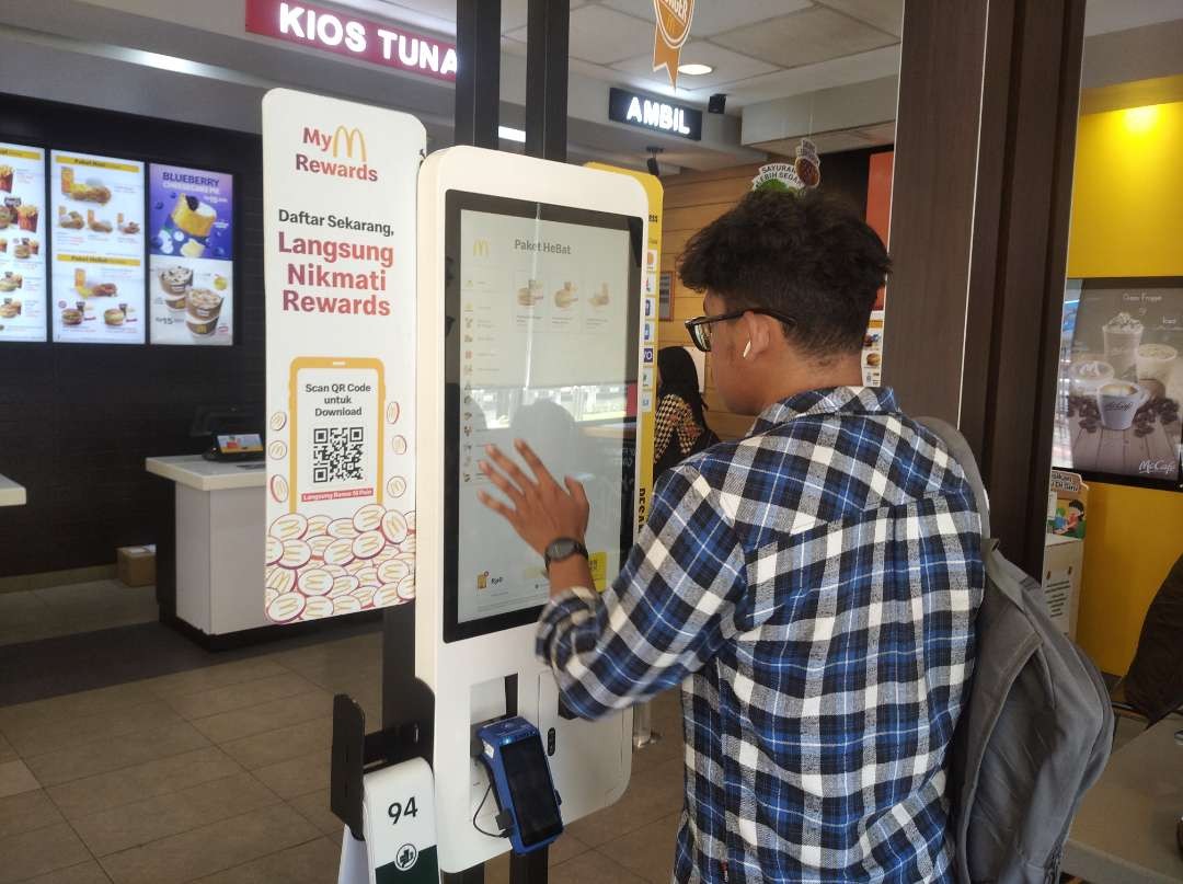 Seorang pengunjung sedang memesan menu di McDonald's Manyar, Surabaya. (Foto: Julianus Palermo/Ngopibareng.id)