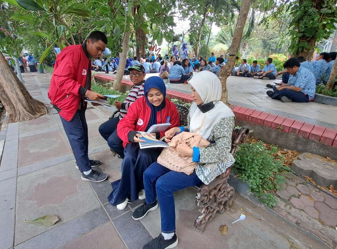 Siswa SMAN 10 Surabaya melakukan Go Book Sepoloh di Taman Bungkul Surabaya. (Foto: Pita Sari/Ngopibareng.id)