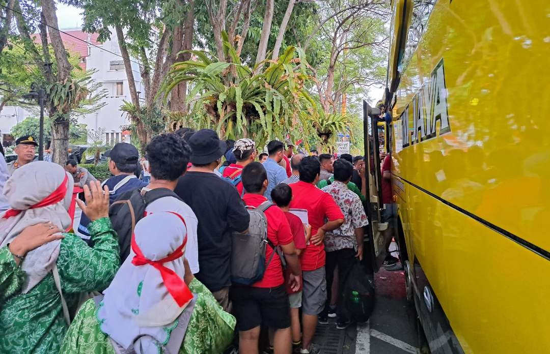 Antrean suporter nonton laga Timnas Indonesia ke Stadion Gelora Bung Tomo (GBT) di Balai Kota Surabaya menunggu shuttle bus. (Foto: Pita Sari/Ngopibareng.id)