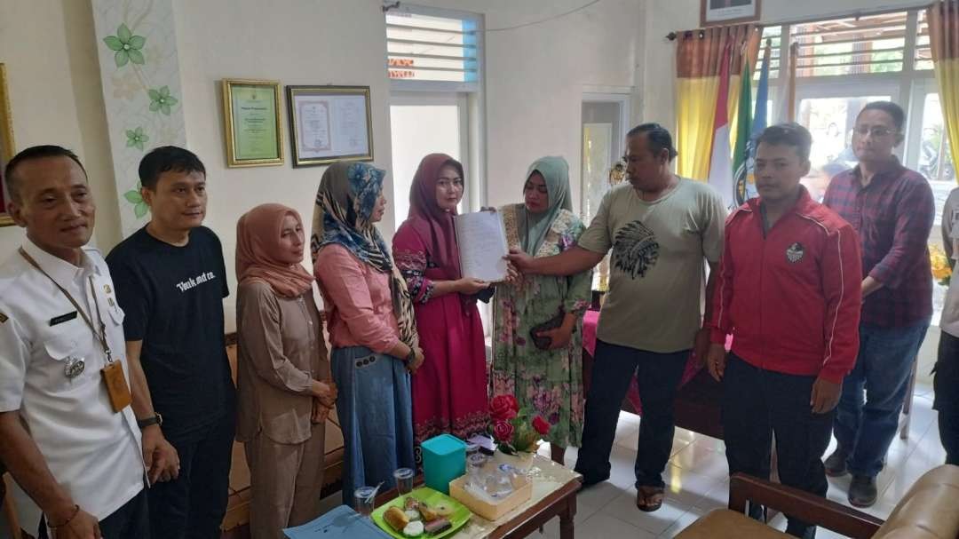 Para orang tua siswa yang terlibat dalam masalah dugaan perundungan menunjukkan surat pernyataan damai. (Foto: Muh Hujaini/Ngopibareng.id)