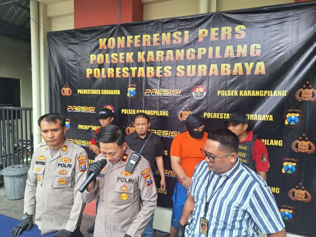 Pelaku AP alias LN (berkaus oranye) diamankan Polsek Karangpilang karena melakukan penganiayaan. (Foto: Julianus Palermo/Ngopibareng.id)