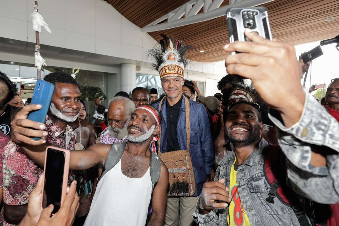 Capres nomor urut 3, Ganjar Pranowo, diajak berselfi oleh masyarakat yang menyambutnya begitu tiba di Merauke, Papua. (Foto: Tim Media Ganjar)