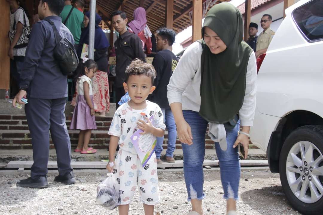 Gemar ikan: Seorang ibu bersama anaknya di acara pembagian ikan segar di Balai Desa Ngrandu Kecamatan Kauman, Ponorogo, Senin 4 Desember 2023. (Foto: dok. kominfo ponorogo)