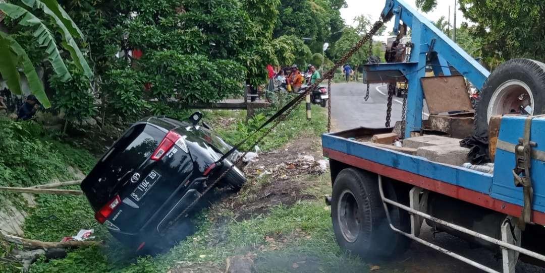 Kondisi mobil Kijang Innova yang masuk ke sungai sedang diderek untuk dievakuasi (Khoirul Huda/Ngopibareng.id)