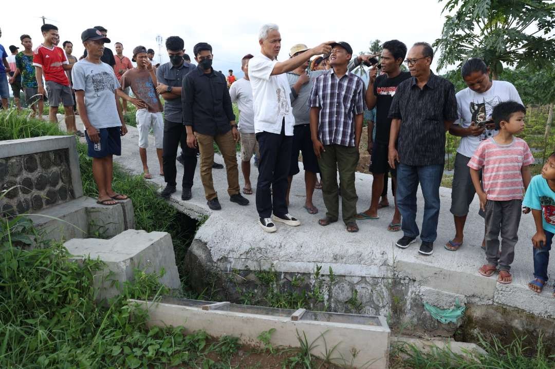 Calon Presiden nomor urut 3 Ganjar Pranowo menemui petani yang nekat menghadang dan menghentikan mobil di sawah sisi jalan, di Desa Sumberarum, Kecamatan Tempuran, Kabupaten Magelang, Jawa Tengah. (Foto: dok. Istimewa)