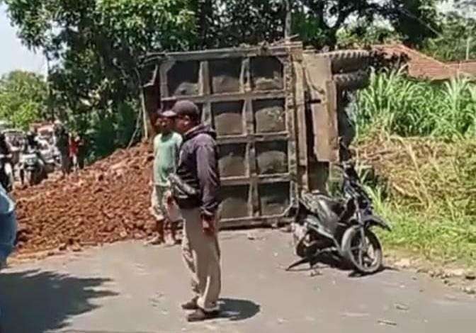 Truk pengangkut material jalan tol terguling di Jalan Raya Desa Condong, Kecamatan Gading, Kabupaten Probolinggo. (Foto: Ikhsan Mahmudi/Ngopibareng.id)