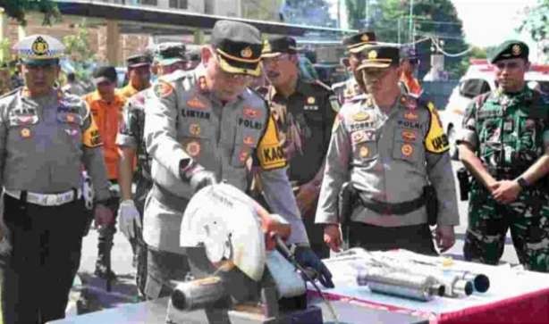 Kapolres Bondowoso AKBP Lintar Mahardhono memusnahkan knalpot brong dengan mesin gerinda.(Foto: Guido/Ngopibareng.id)