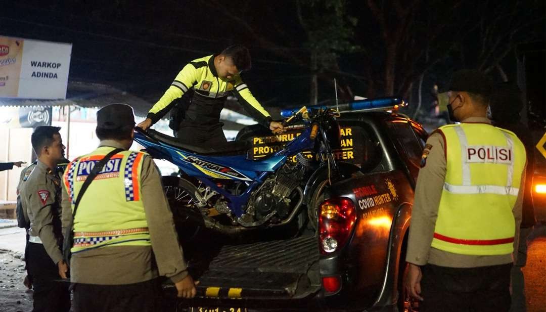 Petugas dari Polres Malang saat mengamankan sepeda motor yang digunakan balap liar di Jalibar, Kecamatan Ngajum, Kabupaten Malang pada Sabtu, 23 Desember 2023 dini hari. (Foto: Dokumen Polres Malang/Ngopibareng.id)