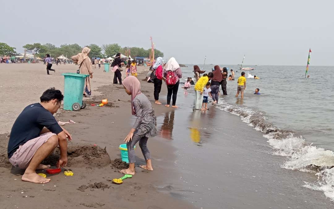 Bermain di pantai Tanjung Pasir bersama keluarga saat menikmati libur Nataru. (Foto: Asmanu Sudharso/ngopibareng.id)