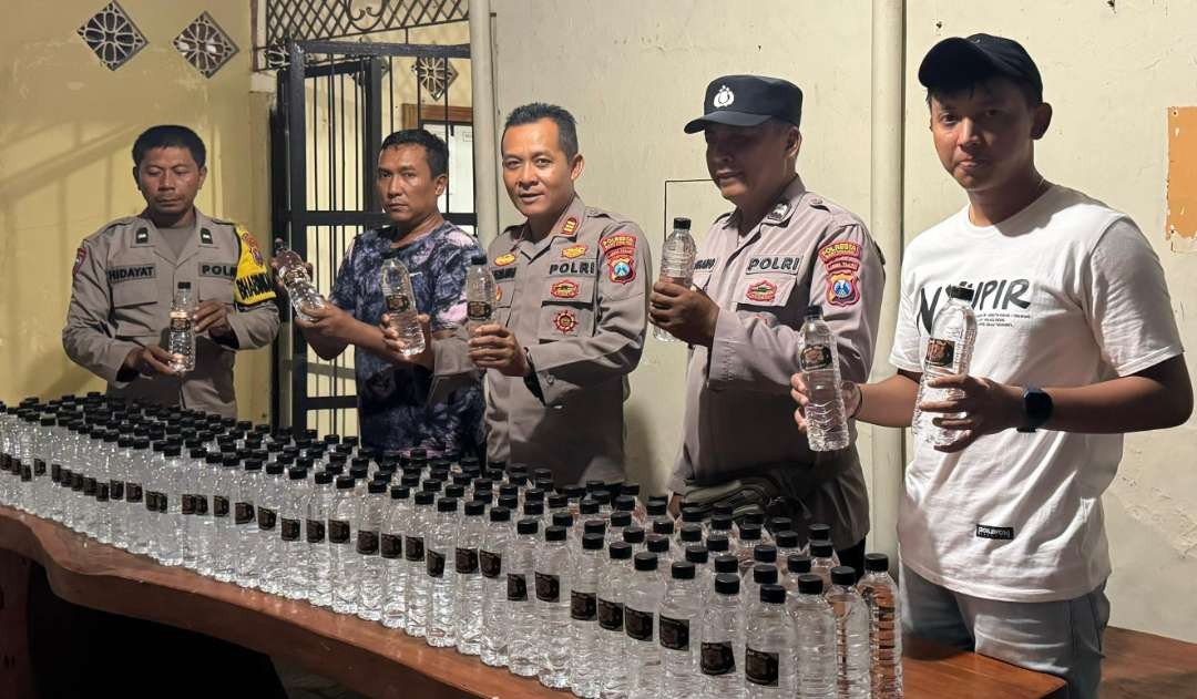 Kapolsek Purwoharjo, AKP Budi Hermawan menunjukkan minuman keras yang disita. (Foto: Istimewa)