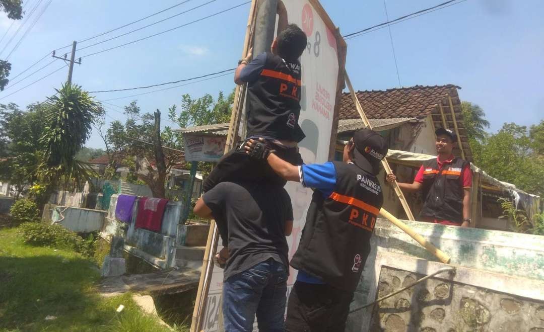 Petugas Bawaslu Jember saat menertibkan APK yang melanggar (Foto: Dok Bawaslu Jember)