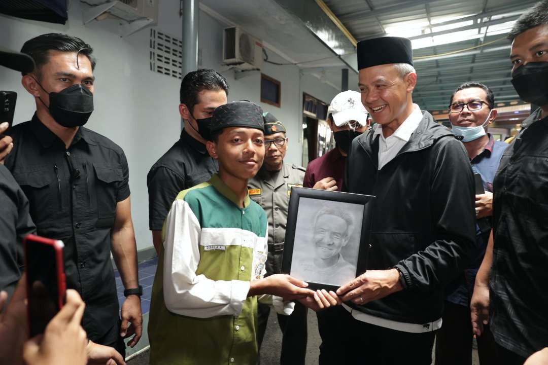 Seorang santri bernama Qubaila Amrullah itu memberikan karya lukis pensil bergambar wajah Capres nomor urut 3 Ganjar Pranowo di Pondok Pesantren Al Ihya Ulumaddin Desa Sentolokawat, Cilacap, Selasa 9 Januari 2024.(Foto: istimewa)