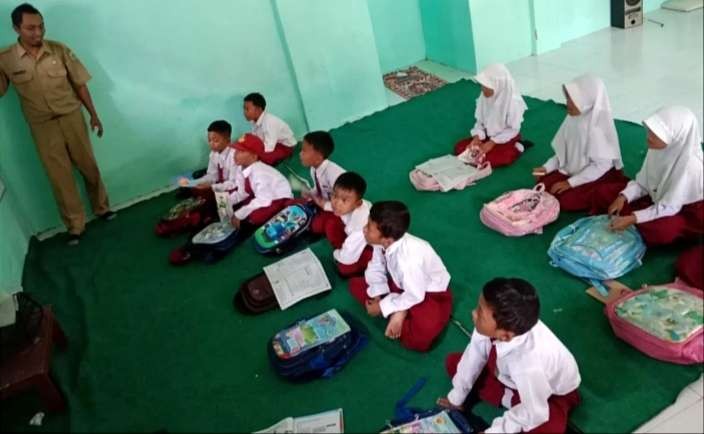 Para siswa SDN Dawuhan Tenggarang Bondowoso belajar lesehan di musala, karena gedung sekolah rusak sejak  Maret 2023 tak kunjung diperbaiki hingga sekarang.(Foto:Dokumen SDN Dawuhan Bondowoso)