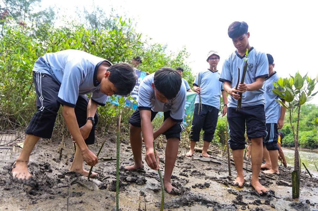 Siswa SMA Al-Muslim Sidoarjo tanam pohon mangrove di Pulau Lusi. (Foto: Aini Arifin/Ngopibareng.id)