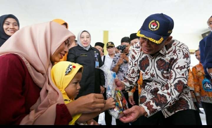 Menko PMK Muhadjir Effendy menyerahkan bantuan pangan beras cadangan pangan pemerintah di Paciran, Lamongan. (Foto: Kemenko PMK)