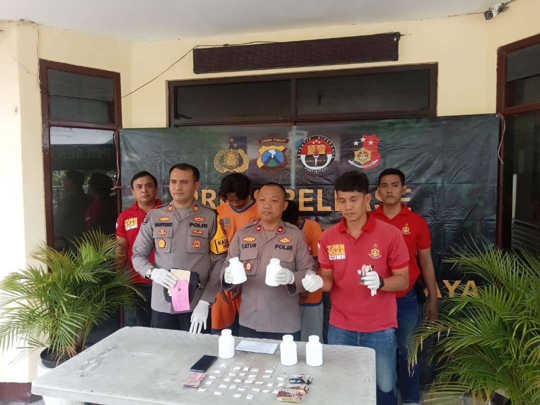 Kapolsek Gayungan Kompol Catur Sulistyantomo dan Kasi Humas Polrestabes Surabaya AKP Haryoko Widhi saat rilis barang bukti pil koplo di Polsek Gayungan, Selasa 16 Januari 2024. (Foto: Julianus Palermo/Ngopibareng.id)