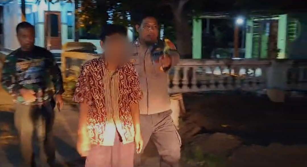 Terduga pelaku saat diamankan polisi.(Foto Deni Lukmantara/Ngopibareng)