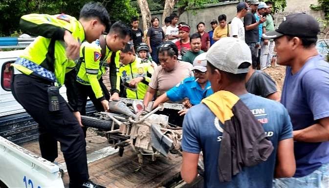 Anggota Satlantas Polres Situbondo mengamankan dua motor ringsek ditabrak dump truk muatan tanah urukan di Panarukan Situbondo.(Foto:Satlantas Polres Situbondo) 