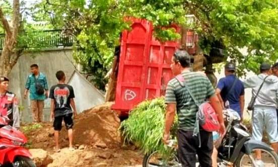 Dump truk muatan tanah urukan terguling di pinggir jalan raya Panarukan Situbondo  usai menabrak 2 sepeda motor.(Foto: Satlantas Polres Situbondo)