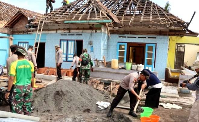 Anggota TNI, Polri, BPBD, dan warga desa memperbaiki rumah rusak akibat puting beliung terjang Kecamatan Prajekan Bondowoso.(Foto: Guido/Ngopibareng.id)